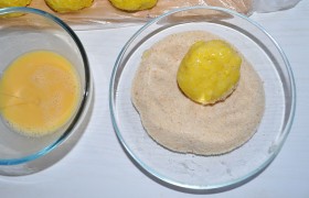 кладем в панировочные сухари, ими же посыпаем сверху, поворачиваем, чтобы аранчини ровно запанировался, поправляем в ладонях форму и выкладываем на сухую доску. Если хочется корочку более толстую – проделываем обе операции еще раз.