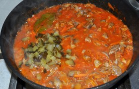 Добавляем к потрошкам натертые (без кожи) помидоры, томатную пасту и кетчуп, доливаем полстакана или немногим больше воды, бросаем лавровые листики, соль, перец. Резко снижаем огонь (после закипания) до средне-слабого, засыпаем мелкие кубики огурцов.
