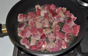 Увеличиваем огонь до сильного, раскаляем жир, выкладываем мясо и обжариваем, не забывая поперчить и помешивая, до легкой румяной корочки. Учитывая его - мяса – количество, лучше сделать это в 2-3 приема, чтобы кусочки не исходили соком, а быстро жарились в один ряд.