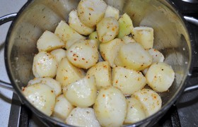 Картофелины очищаем, делим  поперек на половинки и заливаем чистой холодной водой, в которой ей стоит побыть хотя бы час, чтобы выделился лишний крахмал. А мы 1-2 раза сменяем воду. Ставим кастрюлю с водой, закипело – солим воду, опускаем картофель. После закипания варим, снизив огонь и под крышкой, 5 минут. И сразу выкладываем в дуршлаг.
Включаем духовку на 200°. Пока греется, поливаем картофель растительным маслом, перчим, если требуется – досаливаем.