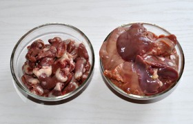 Самым тщательным образом, до самой чистой воды промываем потрошки (если у нас есть время – хотя бы на полчаса замачиваем их в миске с водой). После этого, сложив в дуршлаг, отцеживаем воду и основательно подсушиваем с помощью бумажных полотенец. Сердечки делим вдоль пополам, печенки разделяем на 2 части, попутно срезая лишний жир и протоки.