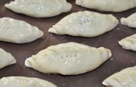 О том, как изделия жарить или печь, сказано выше. Те, что собираемся печь в духовке, перед посадкой в нее смазываем маслом или взбитым яйцом, делаем пару проколов вилкой, даем немного подойти. Из этого количества теста получаются, в зависимости от размера, 32-36 пирожков.
