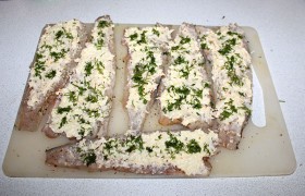 Наносим смесь на филе минтая и посыпаем рубленой зеленью укропа.