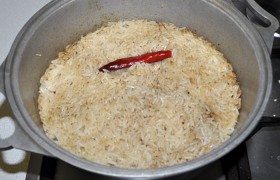 Когда воды на рисе уже не останется - кладем стручки перца. В это же время немного убавляем огонь, чтобы мясо и морковь не пригорели.