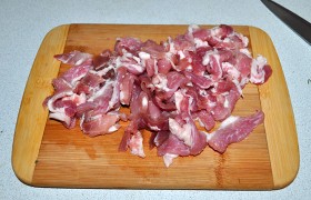Берем острый нож и нарезаем кусок мяса мелкими и тонкими (не больше 5 мм) ломтиками. Посыпаем перцем и специями. Пока мы этим занимаемся, на тяжелой просторной сковороде, установленной на самый большой огонь, успевает  перекалиться масло  (4-5 минут). 