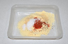 Насыпаем для панировки кукурузную муку, которая дает отличную корочку, тонкую, золотистую, вкусную. Добавляем соль, чеснок, паприку, перец, перемешиваем. 