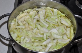 Тем временем мясо вынимаем, бульон процеживаем. Мясо освобождаем от кости, нарезаем, возвращаем в бульон, солим, бросаем перец, лаврушку. Шинкуем и отправляем в бульон капусту. Варим под крышкой.