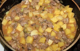 Когда становятся почти мягкими кусочки желудков – кладем в сковороду (или, если она мала, всё перекладываем в кастрюлю) нарезанную картошку и, добавив в меру необходимости горячей воды, оставляем тушиться. Через 10 минут добавляем мелко нарезанные огурцы, еще через 5-7 – нарезанный чеснок, солим и тушим до готовности картошки. Готовое блюдо 10 минут оставляем на выключенной конфорке, подаем, посыпав петрушкой.