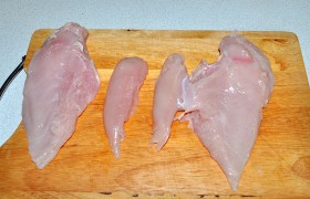 Промытые и обсушенные бумажными полотенцами куриные филе кладем на доску вниз той стороной, где находится пленка. Отделяем малые филе (миньоны).