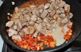 и заливаем в сковороду с луком и томатной пастой, возвращаем сюда и свинину. И добавляем набухшие, заранее замоченные черносливины.