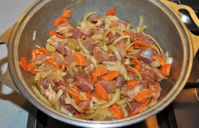 Промытое мясо нарезаем некрупными кусками. Добавляем горчицу, хорошо перемешиваем – и кладем свинину в щедро смазанный маслом казан (другую посуду для тушения). Сюда же – полукольцами шинкованный лук, нарезанную морковку.