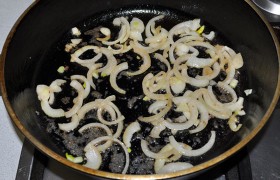 Полукольцами нарезанный лук, помешивая, быстро слегка подрумяниваем, добавляем чеснок.