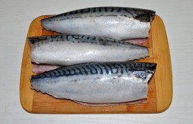 Скумбрию, которая медленно размораживалась по всем правилам на нижней полке холодильника, избавляем от внутренностей, головы и плавников, промываем как следует под струей воды.