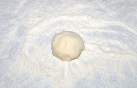 Столовой ложкой опускаем порцию массы в тарелку с мукой, обваливаем, крутим между ладонями, похлопываем. 