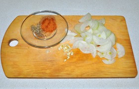 Луковицы шинкуем тонкими полукольцами, рубим ножом дольку чеснока. А на блюдечко выкладываем необходимые по рецепту сухие специи.