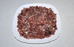 Свекла, картофель, морковь и яйца сварены, полежали в холодной  воде, очищены, нарезаны и натерты, филе сельди – уже в виде мелких кусочков. Вот с него и начинаем сборку салата, уложив кусочки на дно плоского салатника (или высокого).