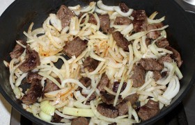 Засыпаем нашинкованный перьями и половинками-четвертинками колец лук, 2-3 минуты жарим мясо с луком вместе.
