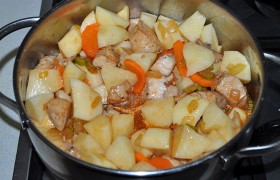 В кастрюлю с мясом добавляем нарезанный картофель, кипяток, которого должно быть столько, сколько нам хочется вкусной подливки. Добавляем заправку со сковороды.
