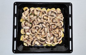 Свеженькие шампиньоны, нарезанные ломтиками вдоль, раскладываем на картошке. И тоже – приправляем.