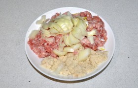 Пропускаем мясо через мясорубку с крупной решеткой. Белый хлеб ломаем на кусочки и поливаем молоком. Очищенный лук крупно нарезаем.