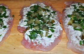 Наносим на каждый отбитый пласт мяса слой творожного сыра, посыпаем рубленой зеленью и мелкими кубиками нарезанных огурчиков, вдавливая их в мясо – так легче плотно свернуть рулет.