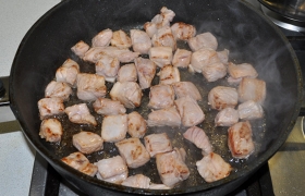 Не меняя огня, закладываем в сковороду мясо и, помешивая, обжариваем кусочки до легких корочек с одной и второй стороны, в общей сложности 3-5 минут.