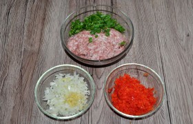 У нас есть фарш, порубленная петрушка, мелким кубиком нарезанная луковица, чеснок, пропущенный через пресс. И сладкий перец, который мы измельчили в крошку в блендере или мелко порубили ножом. Часть сока из перца отжимаем, иначе фарш может оказаться жидковатым.