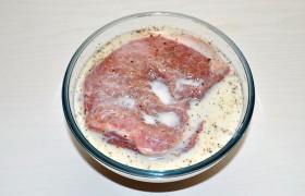 Смешав вместе соль, перец, травы, приправу к мясу, сахар, посыпаем обе стороны отбивных. Складываем и заливаем молоком. Маринуем не менее часа, вкуснее будет – если 2-4 часа и больше. 2-3 раза переворачиваем. Вы заметите, насколько меньше стало молока – мясо впитало его.