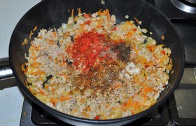 Добавляем мясной фарш, несколько минут, 4-6, обжариваем, разминая его вилкой или лопаткой, не давая образоваться комочкам. Солим, перчим, сыплем специи (орегано, тмин, кориандр).