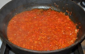 На сковороде, разогрев масло на среднем огне,  пассеруем  мелко порубленную луковицу 7-9 минут. Помидоры разрезаем на половинки, натираем, отбрасывая шкурки. Добавляем к луку, тушим 3 минуты. Кладем томатную пасту, сахар, хмели-сунели, немного перца и соли. Через минуту добавляем пару половников бульона, тушим 2-3 минуты.