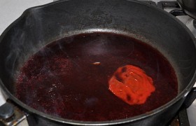 В освобожденную сковороду вливаем бульон и вино, кладем ложку аджики, посыпаем приправой, сахаром, даем соусу 2-3 минуты покипеть.