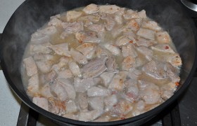 Солим свинину, вливаем немного горячей воды. Пробуем мясо: если обжарили правильно, оно мягкое и сочное. Даем закипеть и тушим пару минут, под крышкой, снизив огонь до минимального.