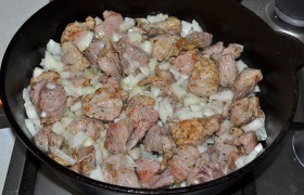 Теперь засыпаем в сковороду лук, нашинкованный средним кубиком, все так же помешивая, жарим 4-5 минут.