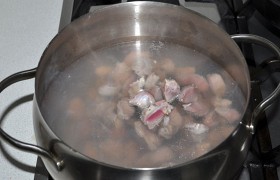 Промываем все потрошки. Желудки нарезаем кусочками поперек и закладываем в кастрюлю с кипящей водой.  Варим , добавив горошки перца, соль. Через 50-60 минут, когда желудки стали почти мягкими – добавляем половинки сердечек. Варим еще примерно 30 минут. 