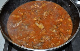 Через минуту-полторы посыпаем мукой, жарим, перемешивая, еще 1-1,5 минуты. Вливаем бульон. Приправляем хмели-сунели (заменить которые можем  Прованскими травами ), паприкой, перцем и солью по вкусу. Кладем измельченный чеснок, рубленую кинзу. После закипания снижаем огонь до среднего, тушим 2-3 минуты.