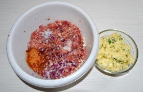В готовый фарш подсыпаем овсянку или замоченный и отжатый белый хлеб, мелко шинкованный лук, соль с перцем, приправу, подливаем примерно полстакана молока (или воды), особенно, если фарш домашний, густой. Как следует вымешиваем и обязательно  отбиваем  20-25 раз. Для начинки соединяем и вымешиваем нарубленные яйца, тертый сыр, чеснок, зелень, майонез, приправы. 