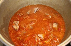 Перекладываем мясо в казанок, добавляем лук с томатом, заливаем горячим бульоном или водой, ждем, пока закипит, и под закрытой крышкой, на малом огне, оставляем тушиться на 20-40 минут – это зависит от сорта мяса.
