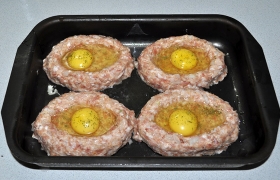 В каждую котлету разбиваем куриное яйцо. Лучше, если это некрупные яйца, либо вообще перепелиные. Но, даже если часть яйца пролилась в форму – ничего страшного, белок просто запечется на дне.