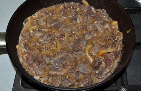 Ставим на сильный огонь сковороду, выкладываем мясо с луком и маринадом. Доливаем полстакана воды. Закипело – накрываем и переводим огонь на небольшой, чтобы мясо тихо кипело-тушилось до мягкости. 