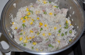 Мясо готово, стало мягким – добавляем к нему рис, горошек и кукурузу, базилик и петрушку. Перемешиваем и под крышкой оставляем тушиться еще 2 минуты. Выключаем, оставляем дойти, под полотенцем, на 5-6 минут.