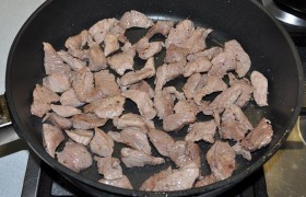 Вторая, большая – для жарки мяса, в ней 4-5 минут  перекаливается  на сильном огне масло. Кладем свинину, на том же огне, перемешивая лопаткой, обжариваем около 3 минут. Кусочки готовы, когда стали светлыми со всех сторон. Солим.