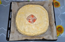 Накрываем раскатанной лепешкой второй половины теста, соединяем по краям, делаем обычную  «веревочку» . В середине – отверстие для выхода пара, оно же – и украшение пирога. Верх с помощью кисточки смазываем слегка взбитым яйцом и посыпаем семенами кунжута. 