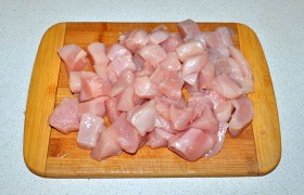 Жарить мы будем в раскаленном масле, потому промытые куриные филе хорошенько подсушиваем в бумажных полотенцах. И нарезаем средними кусочками-кубиками, по 25 мм.