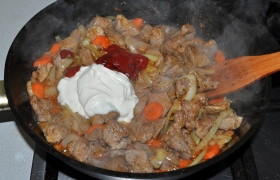 Когда мясо в гуляше почти мягкое, добавляем томатную пасту и сметану, сахар, пробуем на соль, если подливки мало – доливаем кипяток. Тушим еще 5-10 минут.