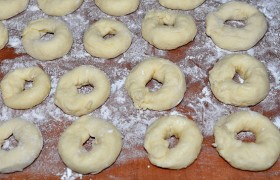 Самый простой способ лепки пончиков: нарезаем небольшими комочками, слегка окунаем ладони в муку и крутим между ними жгутик теста, кончики скрепляем. Толстые не делаем – могут быть проблемы с прожариванием.