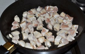 Раскаляем сковородку с маслом на большом огне, в  перекаленное масло  выкладываем индейку, 3-4 минуты обжариваем, перемешивая и переворачивая мясные кубики, до побеления и слабо-румяной корочки. Шумовкой быстро выкладываем на тарелку. 