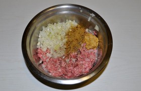 Мясо с помощью мясорубки с крупной решеткой или блендера превращаем в фарш, в который добавляем горчицу, соль, перец, мелко нашинкованный лук. Смешиваем, если фарш суховатый – вливаем молоко или воду, снова вымешиваем и обязательно  отбиваем . 