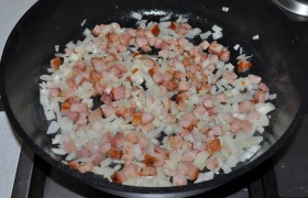 Смазываем дно сковороды маслом, разогреваем на огне больше среднего, кладем бекон и, помешивая, ждем, пока вытапливается жир и бекон слегка подрумянивается. Засыпаем лук, обжариваем 4-5 минут.