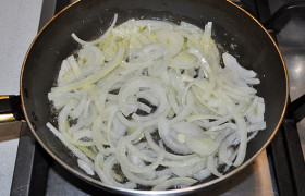 Овощи чистим. Для суповой заправки лук нарезаем полукольцами, выкладываем в разогретое масло и на среднем огне 7-8 минут обжариваем до золотистого цвета и прозрачности, часто помешивая. 