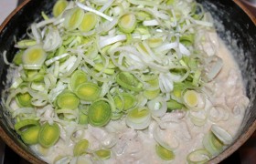 В сковороду с курицей выкладываем ворох лука-порея, перемешиваем, выключаем.
